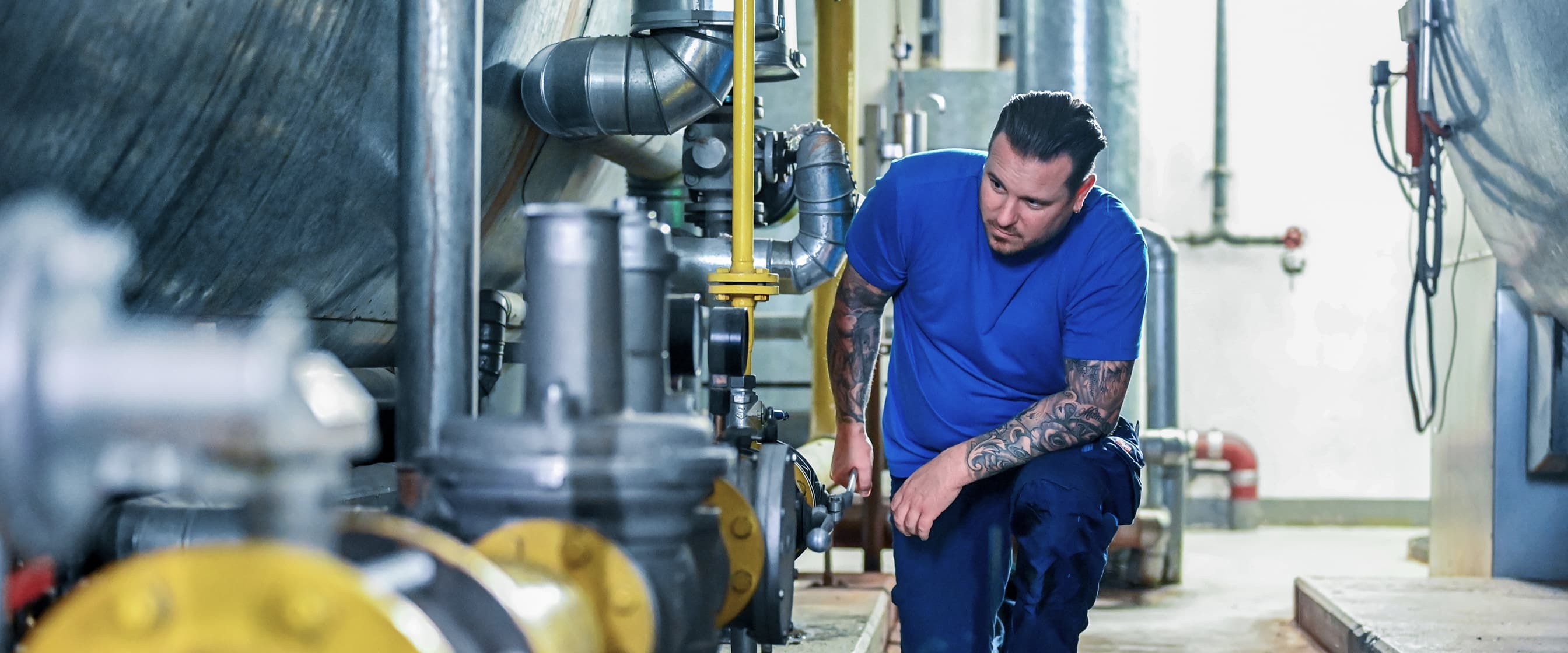 Ein Anlagenmechaniker überprüft eine große Maschine im Keller des Kliniums