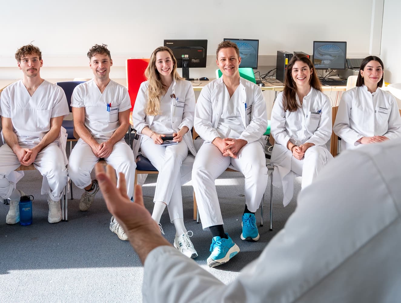 Eine Gruppe von Studentinnen udn Studenten bekommt von einem Oberarzt etwas erklärt