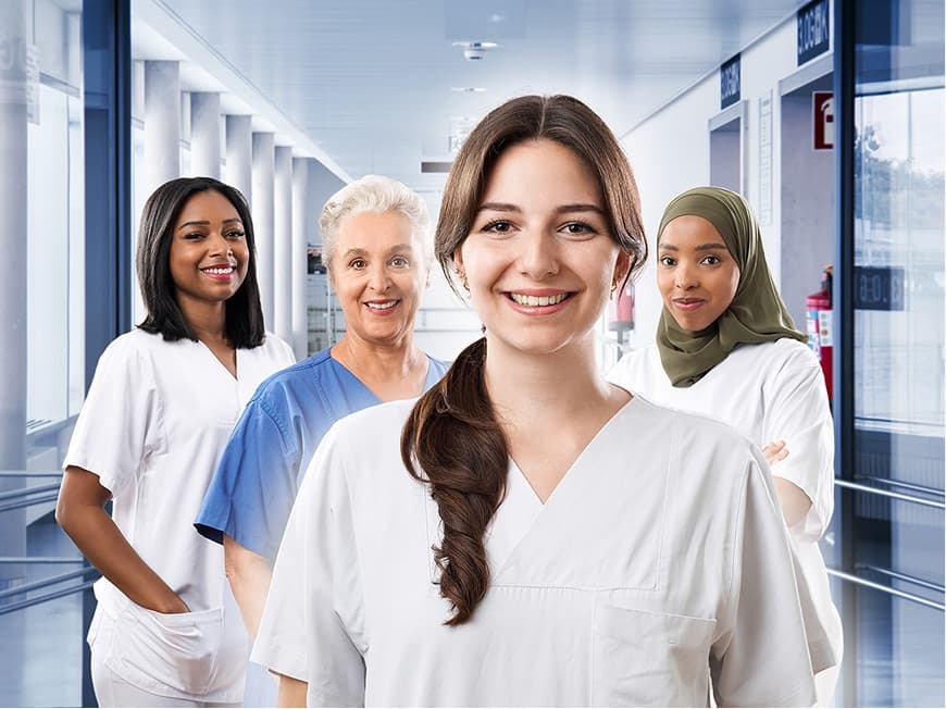 Vier Pflegefachpersonen aus demFlexteam stehen im Krankenhausflur und blicken in die Kamera