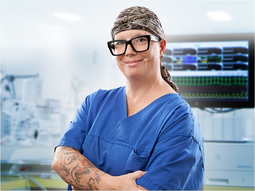 Eine Pflegefachfrau auf der Intermediate Care Station (IMC) blickt in die Kamera