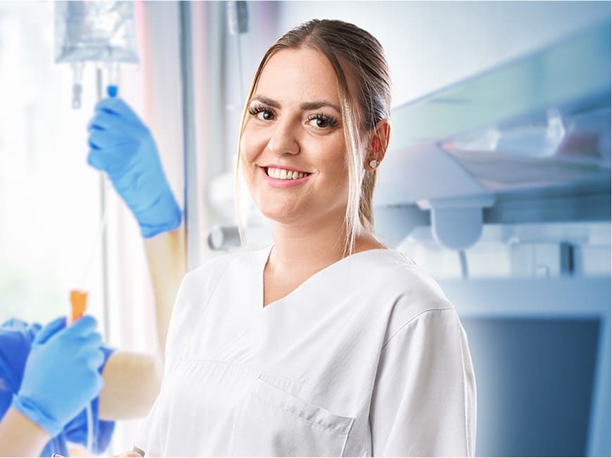 Eine Pflegefachfrau auf der Allgemeinstation blickt in die Kamera