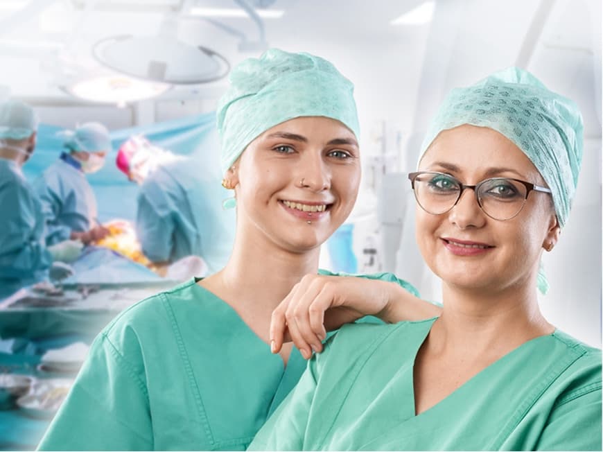 Zwei Pflegefachfrauen im OP blicken in die Kamera