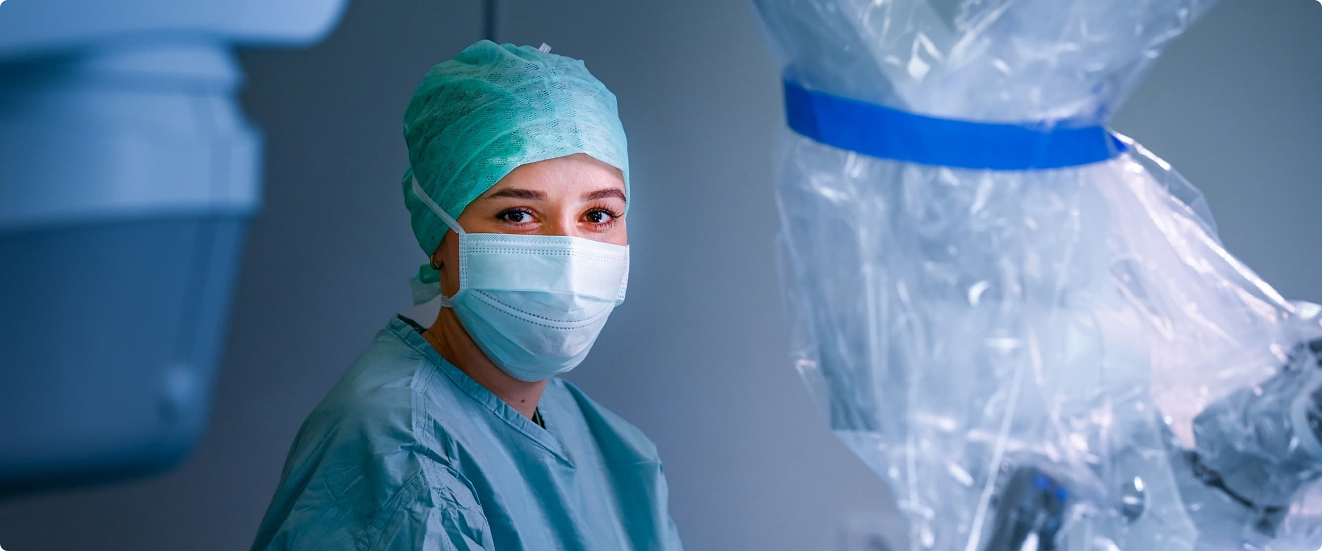 Operationstechnische Assistentin blickt während einer OP in die Kamera