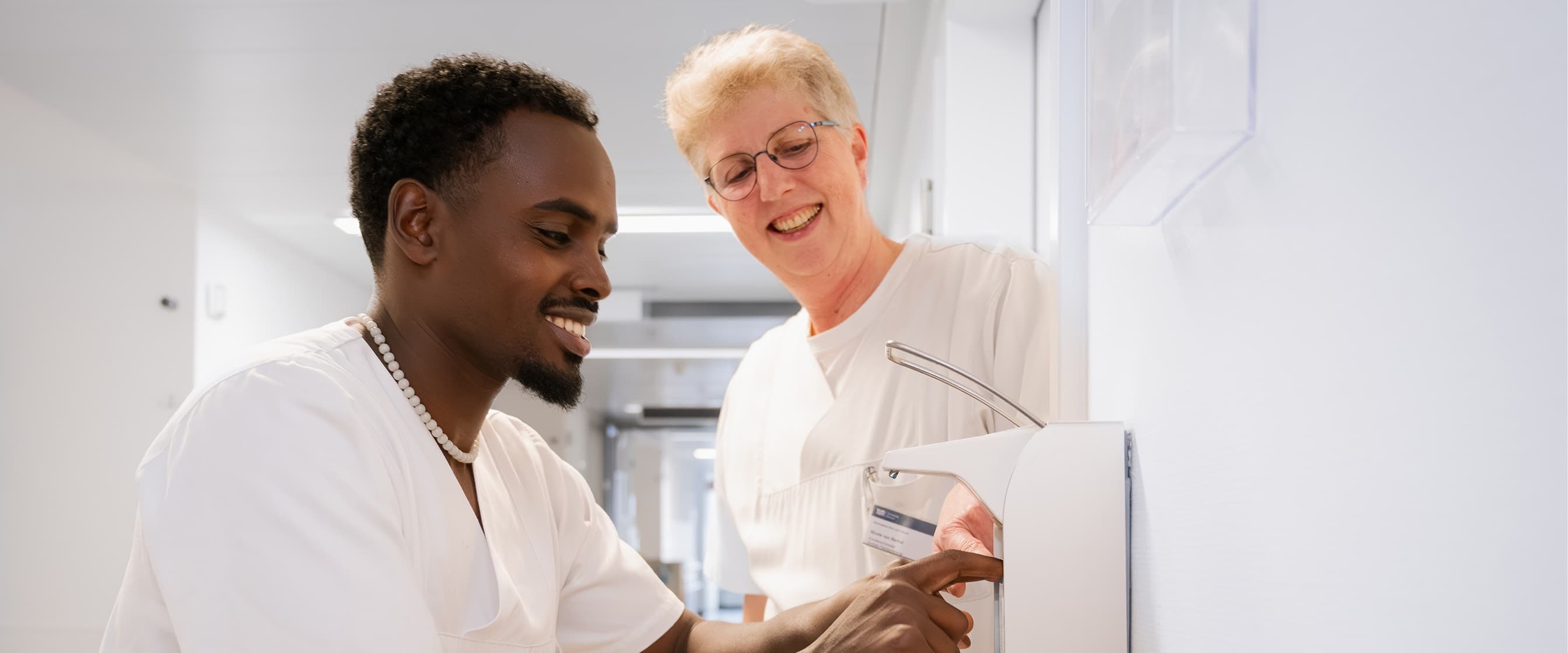 Ein Auszubildender zum Pflegefachhelfer lernt die hygienische Händedesinfektion