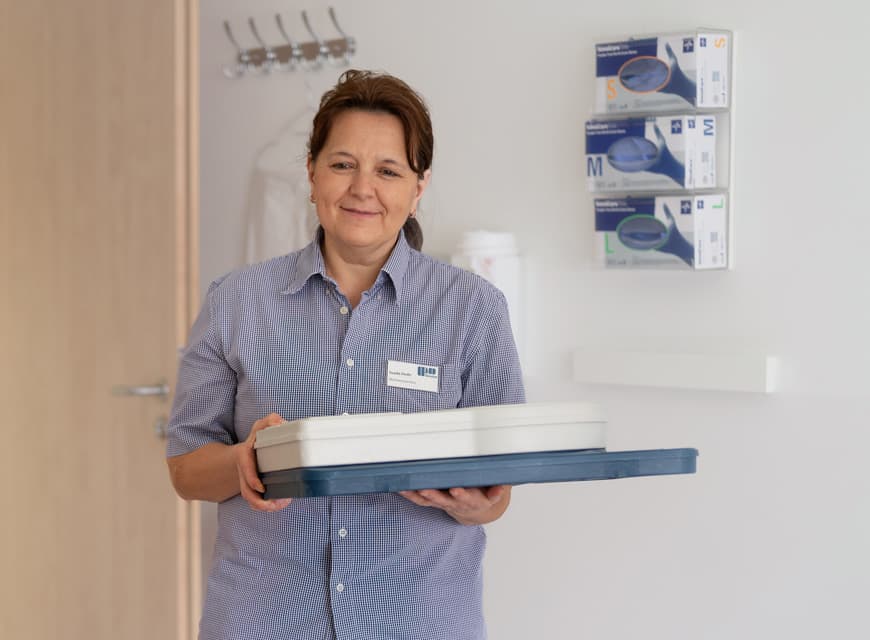 Eine Servicekraft bringt das Patientenessen ins Patientenzimmer