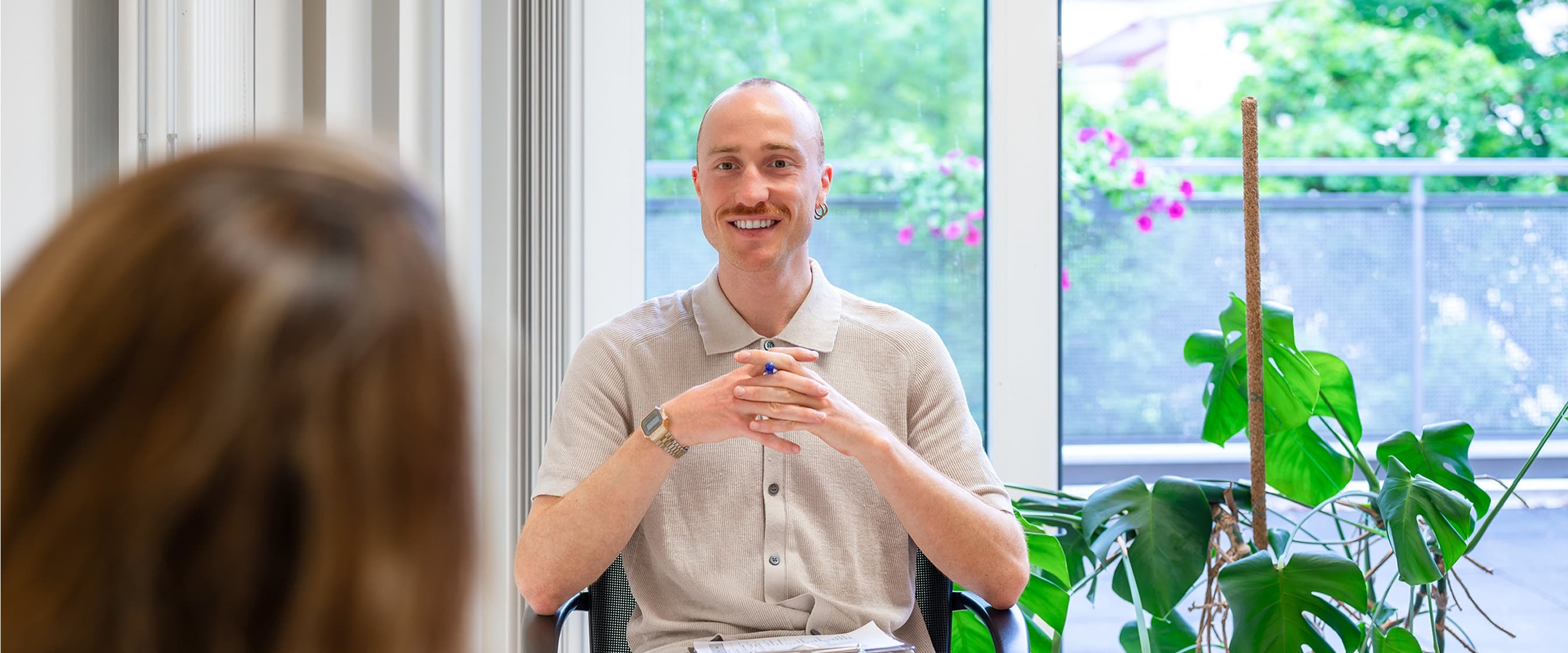 Ein Therapeut sitz in einer Gruppentherapie und hört einer Patientin zu