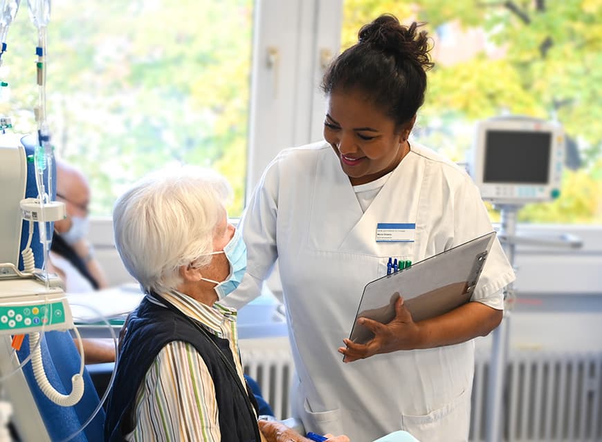 Eine onkologische Fachkrankenschwester betreut eine Patientin bei der Chemotherapie