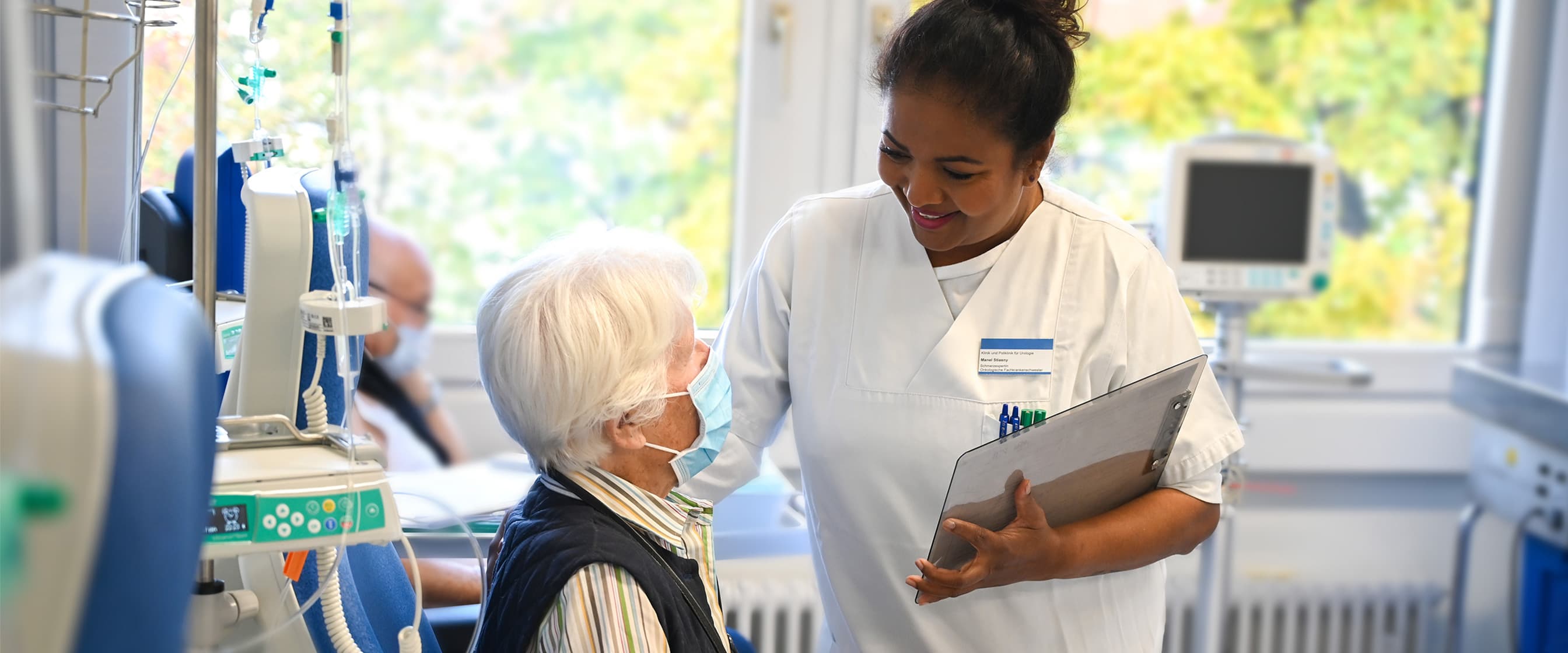 Eine onkologische Fachkrankenschwester betreut eine Patientin bei der Chemotherapie