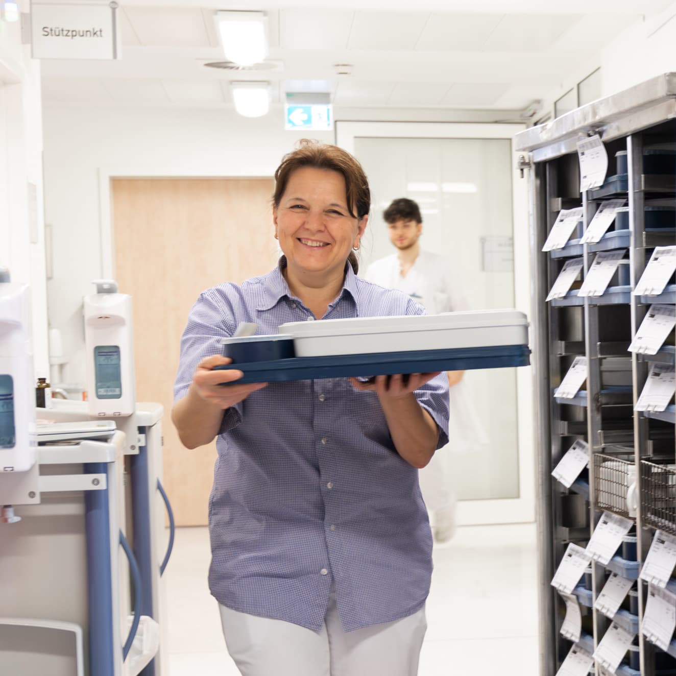 Eine Servicekraft bringt das Patientenessen in die Patientenzimmer